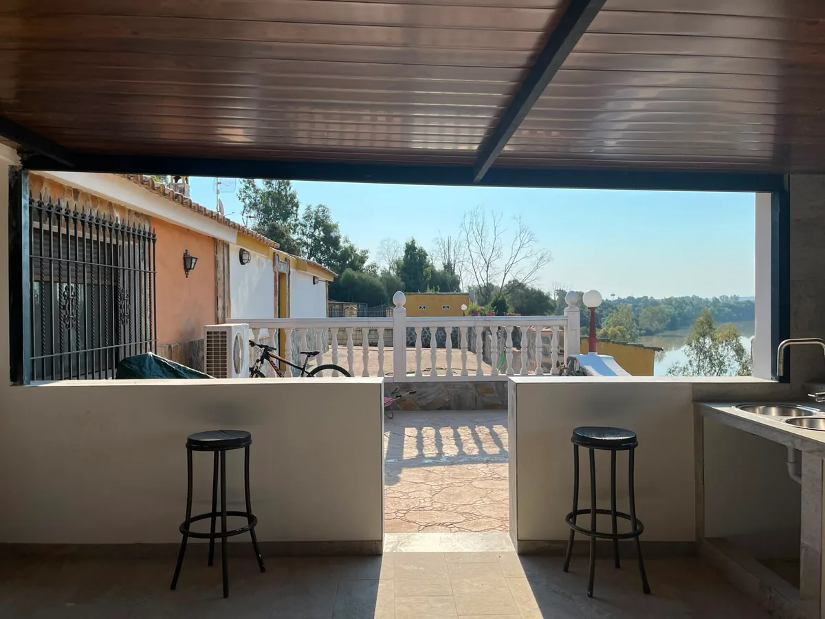 Cerramiento de porche en aluminio completamente abierto sobre barra de cocina exterior — METALISUR Málaga