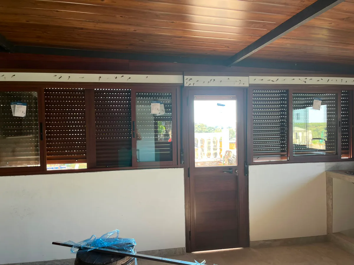 Persianas de aluminio imitación madera vistas desde el interior con las lamas bajadas — METALISUR Málaga