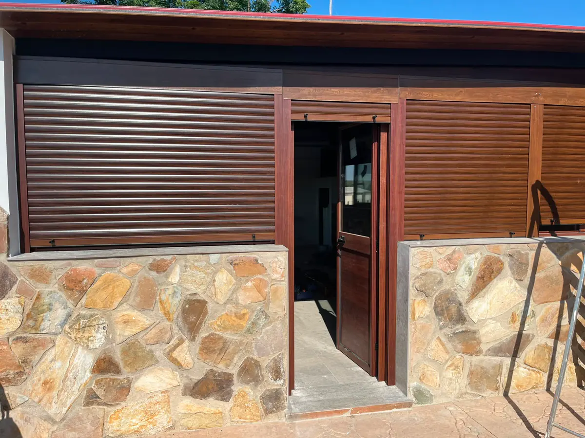 Puerta de aluminio imitación madera con cristal para acceso exterior, con persianas de aluminio a juego — METALISUR Málaga